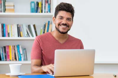 Man smiling sitting at laptop computer