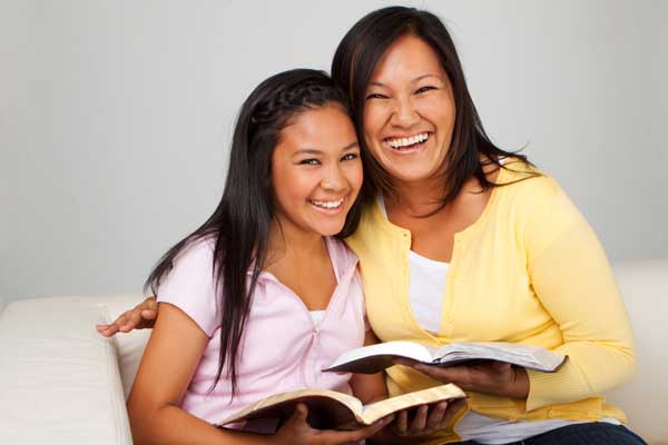 two women smiling for photo holding open books