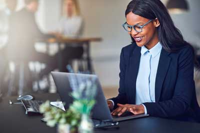 Woman in blue typing on laptop computer